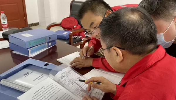 工作组专家检查新疆华醇能源有限公司作业票，并指导员工。